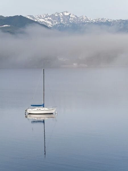 USA, Washington, Seabeck. Sailboat anchored in Hood Canal with Olympic Mountains in background