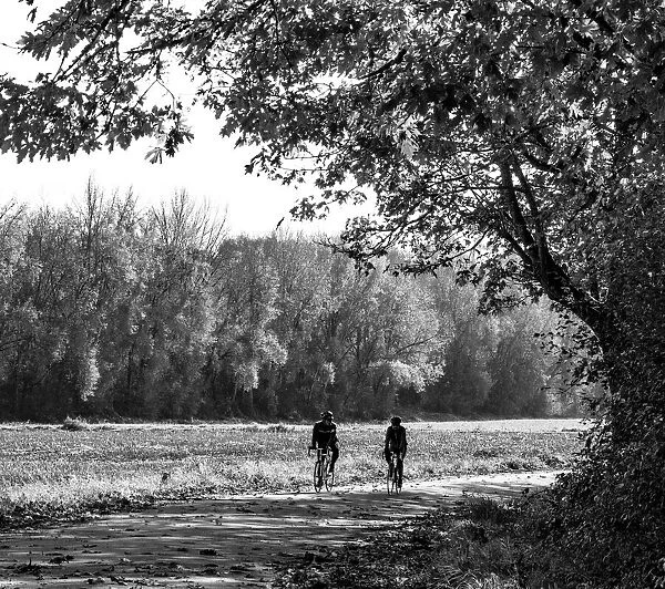 USA, Washington State, Fall City black and white two bike riders along Neal Rd. S. E