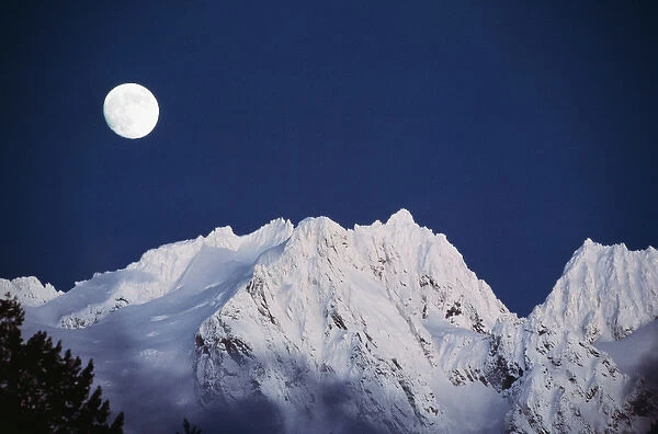 USA, Washington State, North Cascades, Full moon over snowcapped mountain