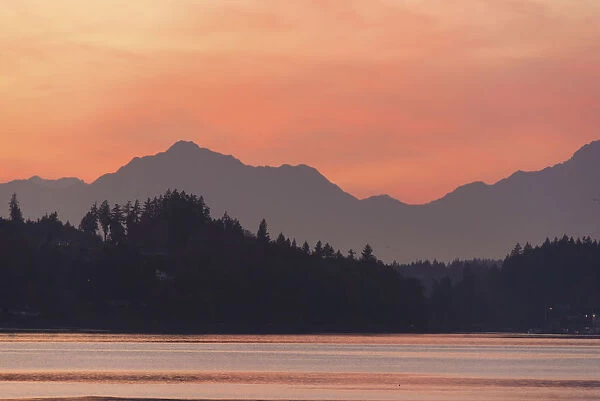 USA, Washington State. Olympic Mountains silhouetted in dramatic light. Calm Puget Sound