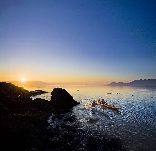 USA, Washington State, San Juan Islands, Doe Island. Two women kayakers at dawn. (MR)