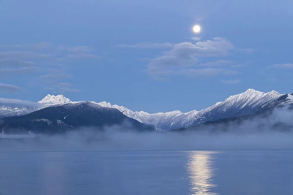 USA, Washington State, Seabeck. Moon setting over Olympic Mountains and Hood Canal