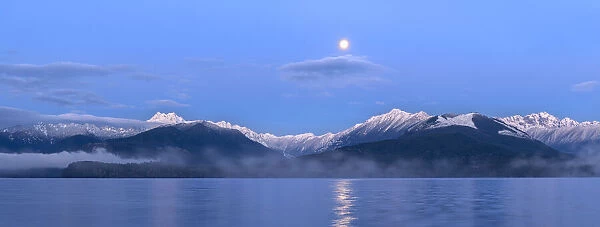 USA, Washington State, Seabeck. Panoramic of moon setting over Olympic Mountains and Hood Canal