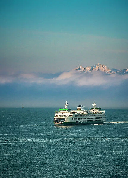 USA, Washington State, Seattle. Ferry sails into Seattle's Elliot Bay in front of morning fog and the Olympic Mountains