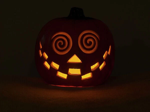 USA, Washington State. Smiling Jack O Lantern face on Pumpkin at Halloween, at night