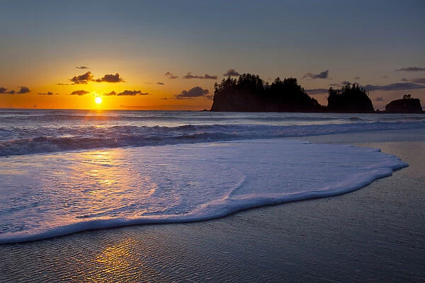 USA, Washington State. A wave rolls up the beach at sunset at La Push on the Olympic