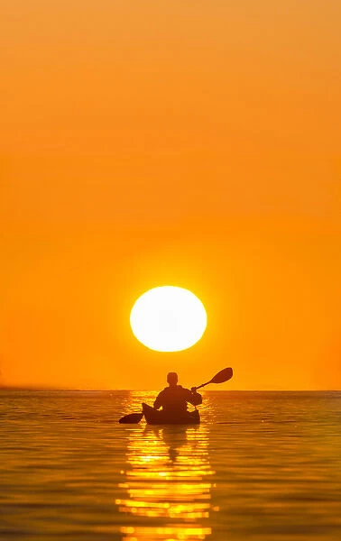 USA, Washington State. Woman sea kayaker paddles on Puget Sound near Deception Pass