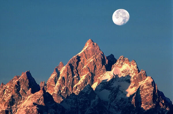 USA, Wyoming, Grand Teton NP. A full moon sets behind the Grand Teton peaks in Grand Teton NP