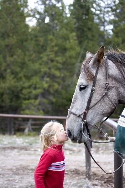 USA. Wyoming. Grand Tetons National Park. Girl kisses horse at a stable in the Tetons