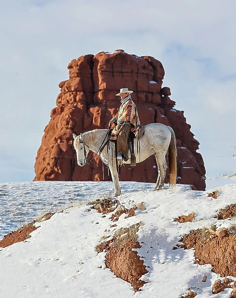 USA, Wyoming. Hideout Ranch cowgirl on horseback riding on ridgeline snow. (PR, MR)