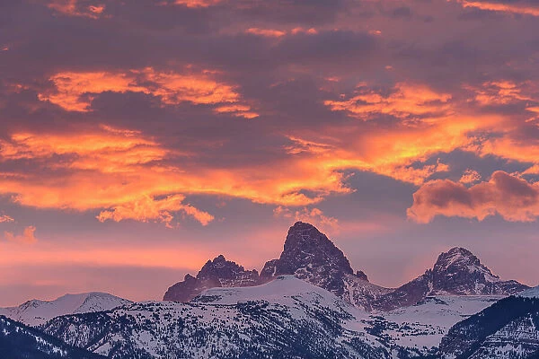 USA, Wyoming. Orange sunset combined with classic landscape of Table, Grand and Middle Teton and Mt. Owen from the west