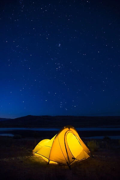 USA, Wyoming, Sublette County. Soda Lake, a tent is lit up against a starry night