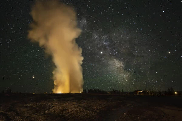 USA, Wyoming, Yellowstone National Park. Milky Way over an erupting Old Faithful Geyser