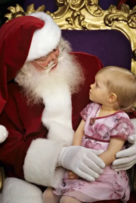 Framed Print : USA. Two year old girl sits on Santa Claus lap (MR) Framed Print : USA. Two year old girl sits on Santa Claus lap (MR)