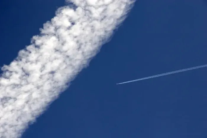 Framed Print : Vapor contrails from high flying jet aircraft. The larger has been blown apart by