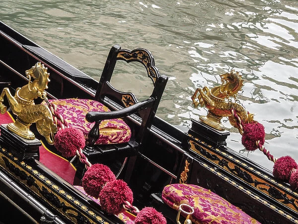 Venice, Italy. Gondola interior adorned with a golden horse serpent, velveteen cushions