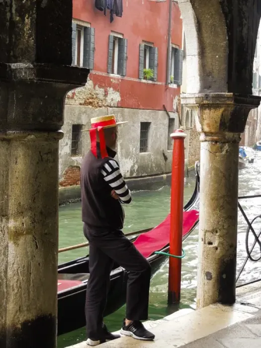 Framed Print : Venice, Italy. Gondolier man looks out onto the canal next to his gondola