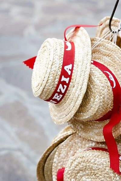 Venice, Veneto, Italy - Straw hats for sale to tourists are hanging from a hook