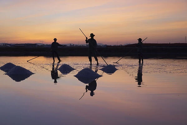 Vietnam. Doc Let Salt lake. Workers harvesting the salt. Early morning sunrise
