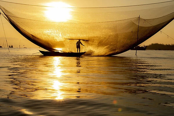 Vietnam. Fisherman emptying the nights catch in the Lagoon