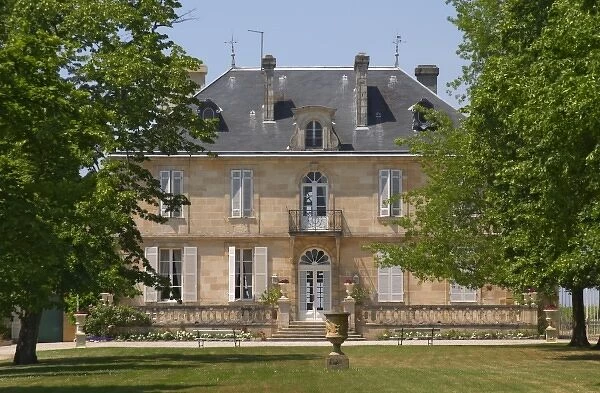 A view of the chateau building across the grass lawn in the garden Chateau Kirwan