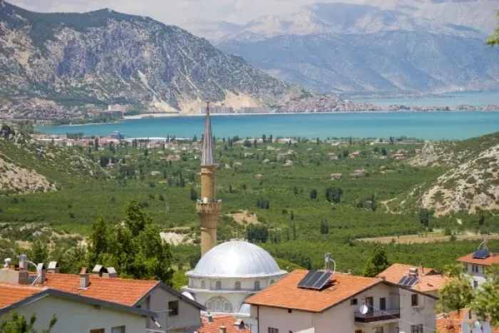 Framed Print : View of Lake Egirdir beyond hilly green land, village mosque with tin dome in front Framed Print : View of Lake Egirdir beyond hilly green land, village mosque with tin dome in front