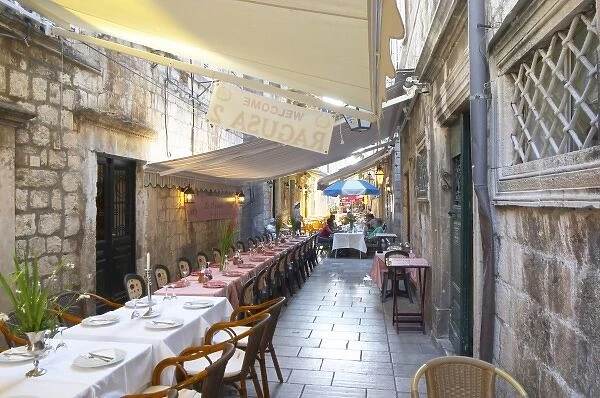 View the Prijeko street with restaurants with outside seating long tables and chairs