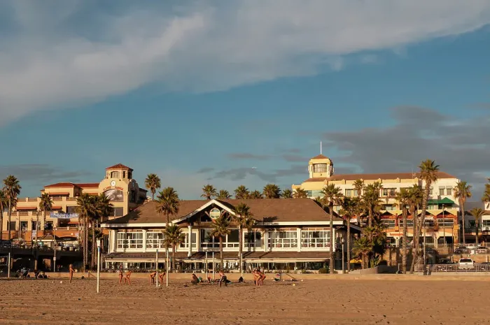 Framed Print : Volleyball players on Huntington Beach fronting sunlit waterfront buildings. Huntington Beach, California, USA. (Editorial Use Only)