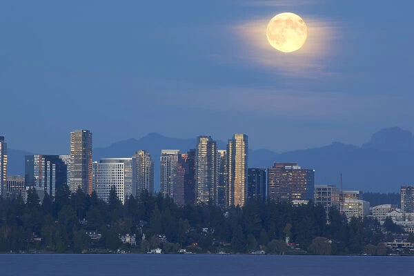 WA, Bellevue, Full moon raising over downtown skyline