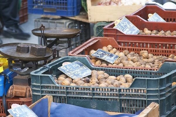 Walnuts for sale in plastic ctrates baskets at a market stall at the market in Bergerac
