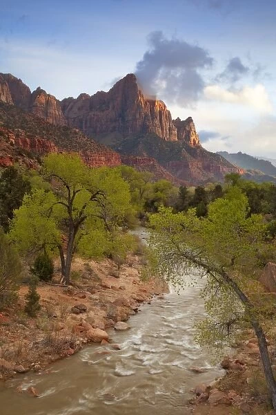 The Watchman Mountain looms over the Virgin River at sunset in Zion National Park in Utah
