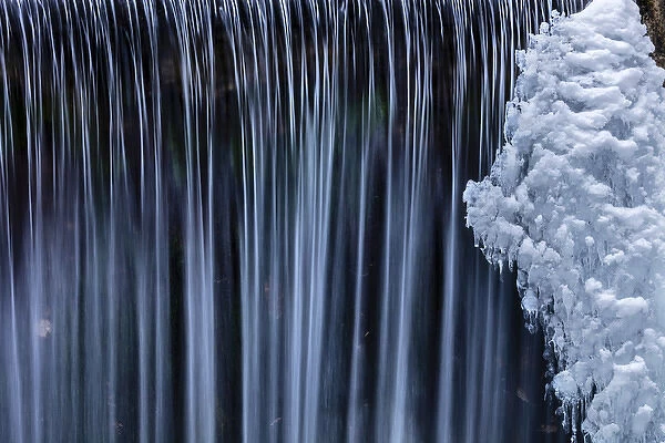 Water flowes by ice formation along Falls Creek in winter near Nelson, British Columbia