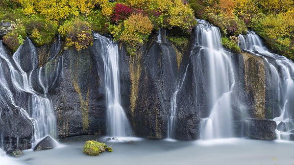 Waterfall Hraunfossar with colorful foliage during fall. Northern Iceland