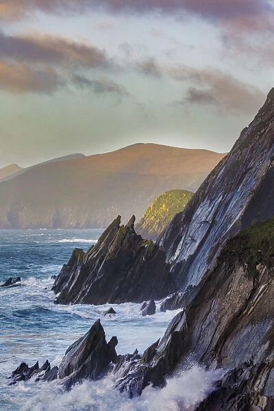 Waves crash into cliffs on Dunmore Head with Blasket Islands on the Dingle Peninsula