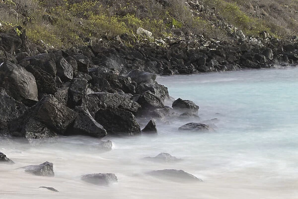 Waves crashing over lava rocks on shoreline of Espanola Island, Galapagos Islands, Ecuador