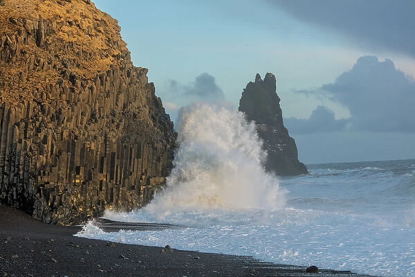 Waves from the North Atlantic Ocean crash into basalt columns at the Black Beach near Vik