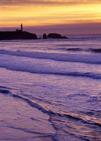 Waves wash in by the Yaquina Head Lighthouse at sunset, near Newport, on the Oregon Coast