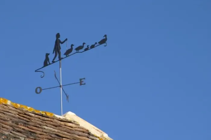 Framed Print : A weathercock weather vane showing a farmer with his or her geese on top of the farm Framed Print : A weathercock weather vane showing a farmer with his or her geese on top of the farm