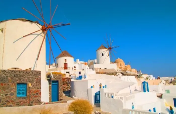 Framed Print : The white buildings and the windmills on the mountain cliffs of Oia, Santorini, Greece