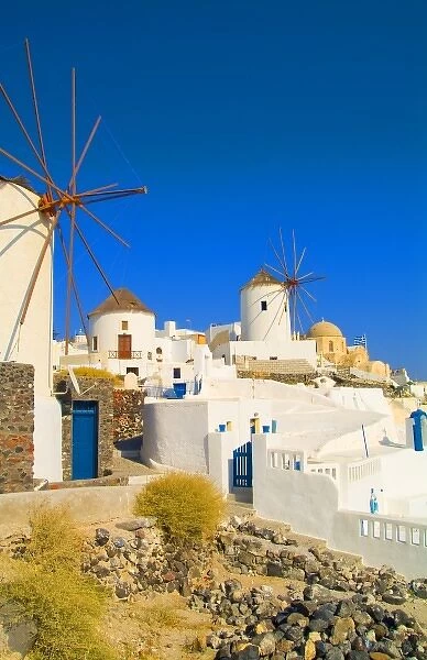 The white buildings and the windmills on the mountain cliffs of Oia, Santorini, Greece
