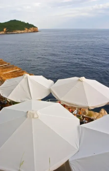 Framed Print : White sun shade umbrellas at a cafe on the city wall overlooking the sea Framed Print : White sun shade umbrellas at a cafe on the city wall overlooking the sea
