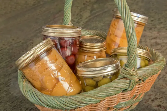 Framed Print : Wicker basket of home canned foods (peaches, olives and cherries) on a granite countertop Framed Print : Wicker basket of home canned foods (peaches, olives and cherries) on a granite countertop