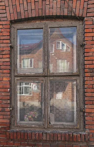 Window in a rowhouse in Wislica, Poland with reflections from the home across the street