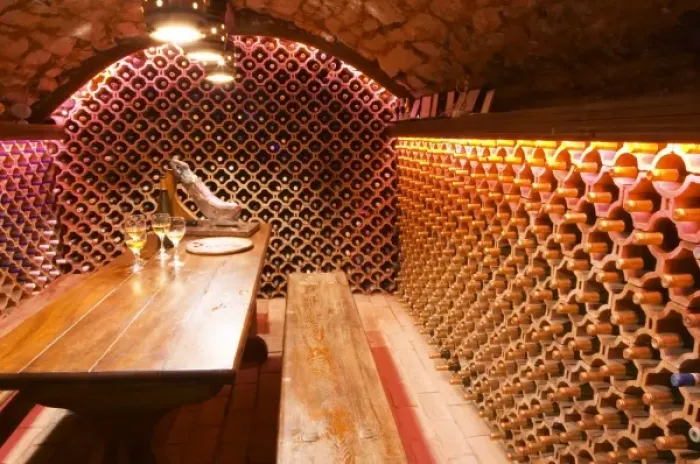 Framed Print : The wine cellar and tasting room, walls are lined with bottles stacked in terracotta