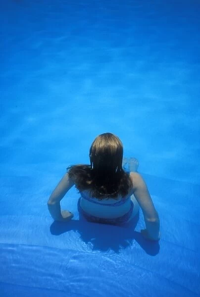 Woman sitting on edge of pool, Manuel Antonia National Park, Costa Rica, MR