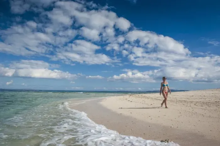 Framed Print : Woman walking along the white sand beach of Beachcomber island, Mamanucas islands