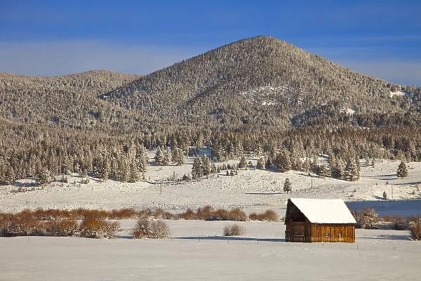 Wooden barn sits in snow near the Boulder River near Basin, Montana