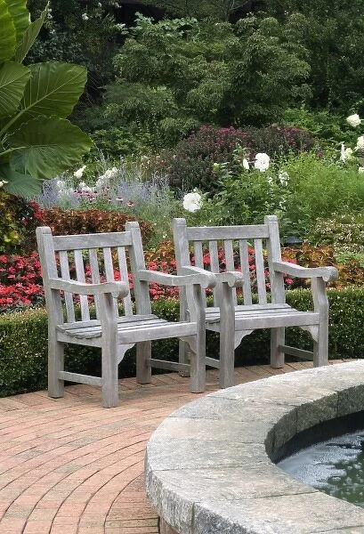 Empty wooden chairs along a garden path