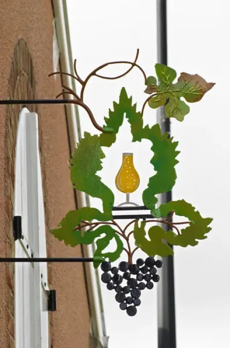 Framed Print : A wrouight iron painted sign that illustrates the theme of champagne and wine production Framed Print : A wrouight iron painted sign that illustrates the theme of champagne and wine production