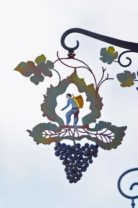 Framed Print : A wrouight iron painted sign that illustrates the theme of champagne and wine production